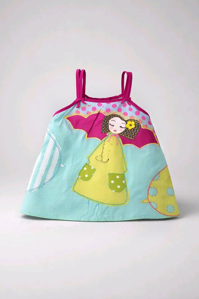 A light blue fabric bag with magenta straps, featuring a colorful applique design of a sleeping fairy in a yellow dress under a pink winged canopy.