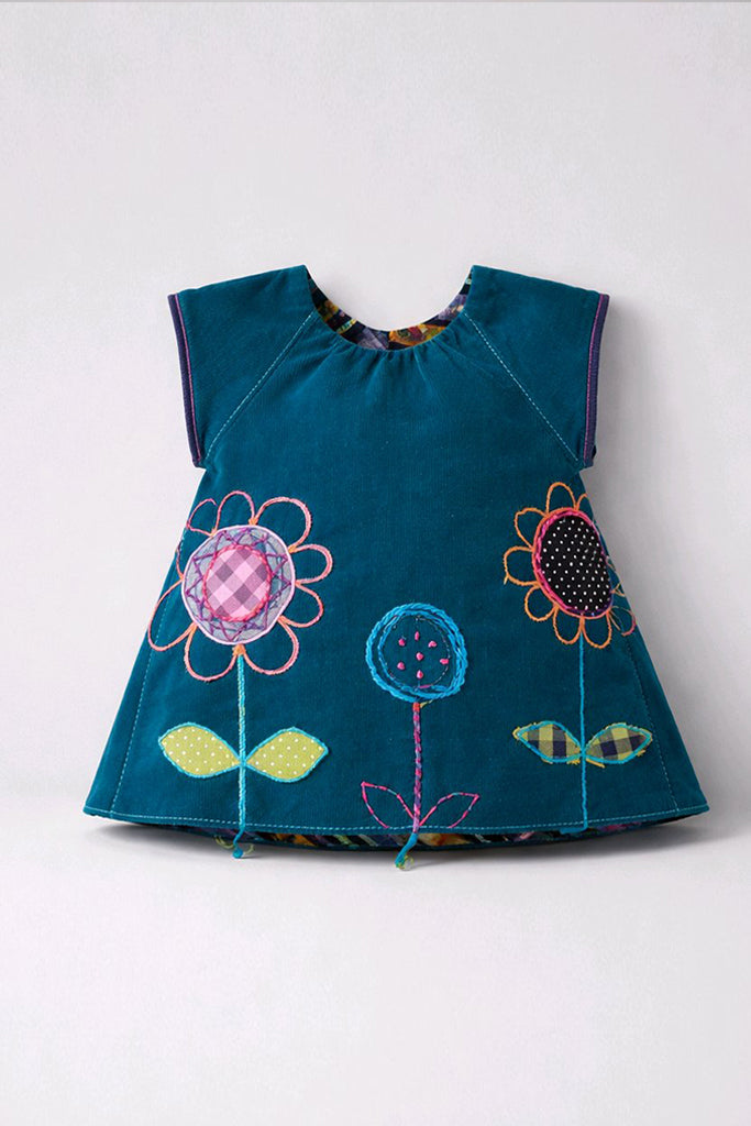 A teal blue baby dress with colorful patchwork applique flowers on the front.