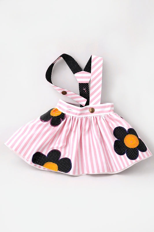 Pink and white striped pet dress with black and yellow flower appliques and black-and-white striped shoulder straps.