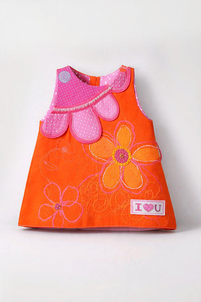 An orange sleeveless baby dress with a pink scalloped collar, featuring embroidered orange and pink flowers, a silver rhinestone accent.