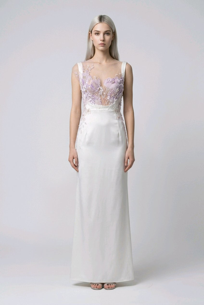 Woman wearing a white gown with floral embellishments.