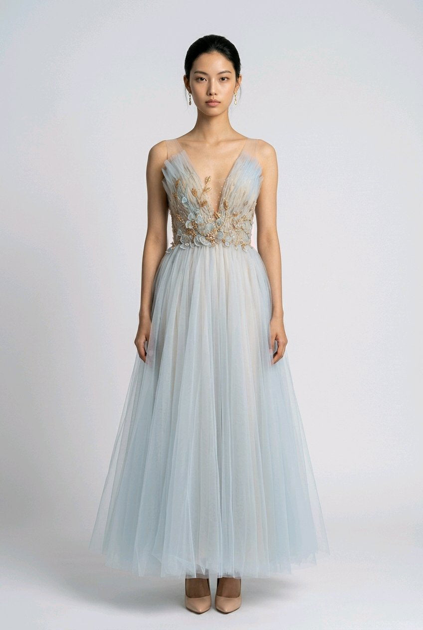 Woman wearing a light blue evening gown with floral embellishments.