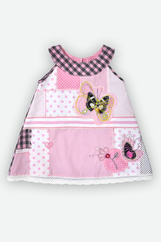 A pink patchwork baby dress with butterfly and ladybug appliques, featuring a gingham collar and various pink patterned fabric panels.