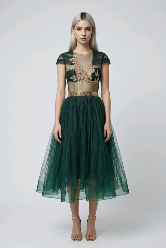 Woman wearing a green dress with floral embroidery.
