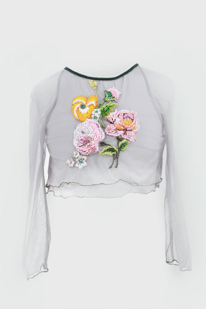 A sheer light gray long-sleeve crop top featuring a colorful embroidered floral design on the front with pink, yellow, and green leves.