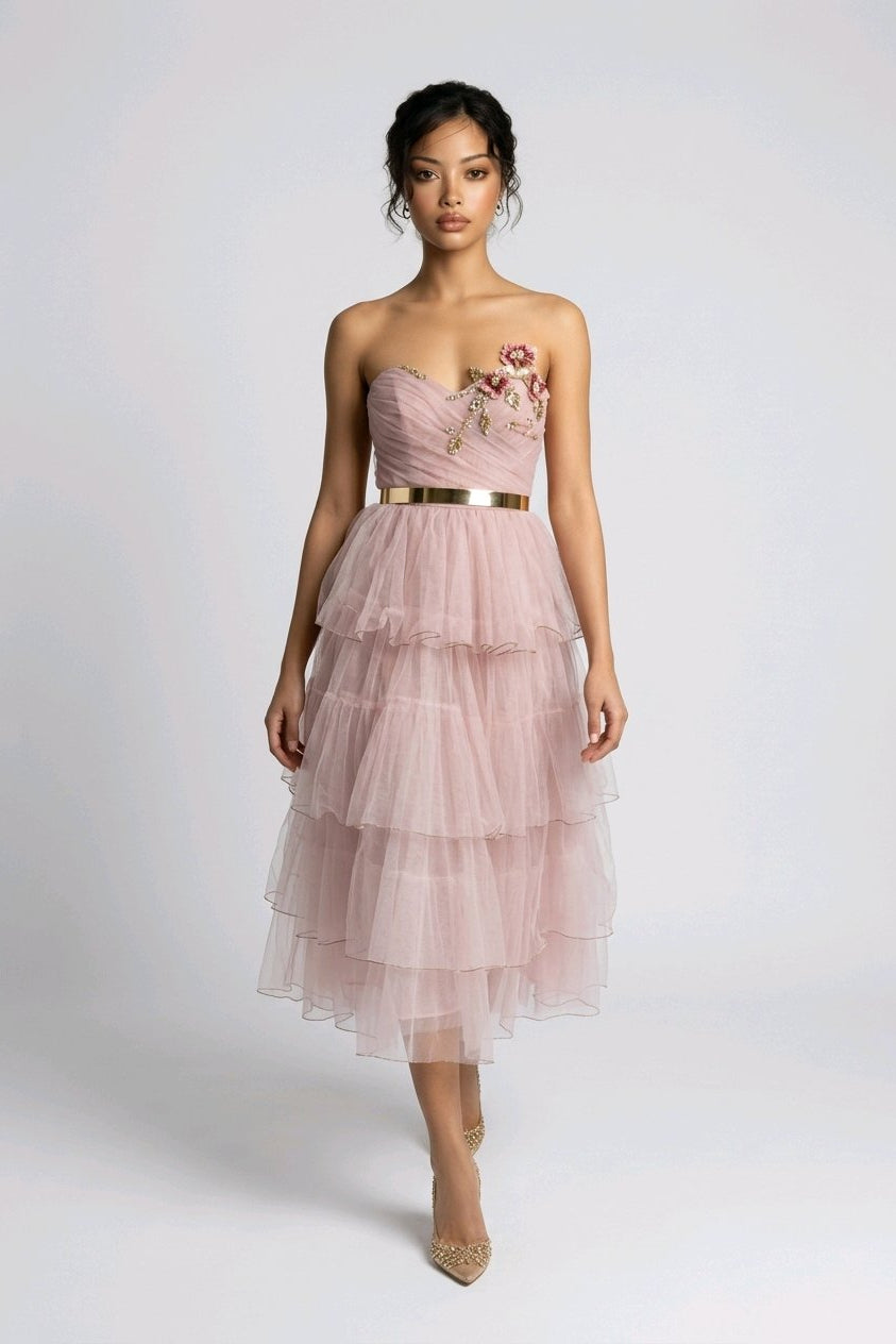 Woman wearing a pink strapless dress with floral details.
