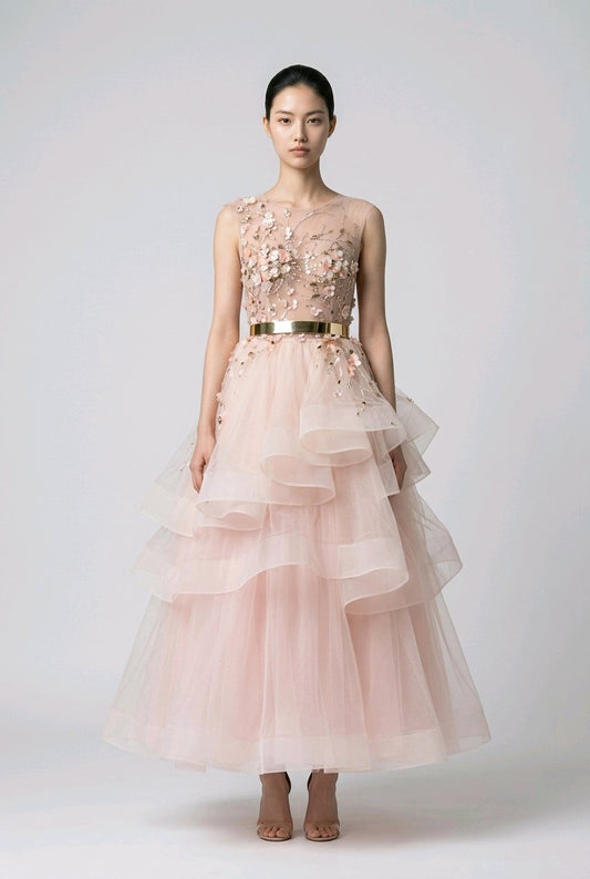 Woman wearing a pink floral dress with a gold belt.