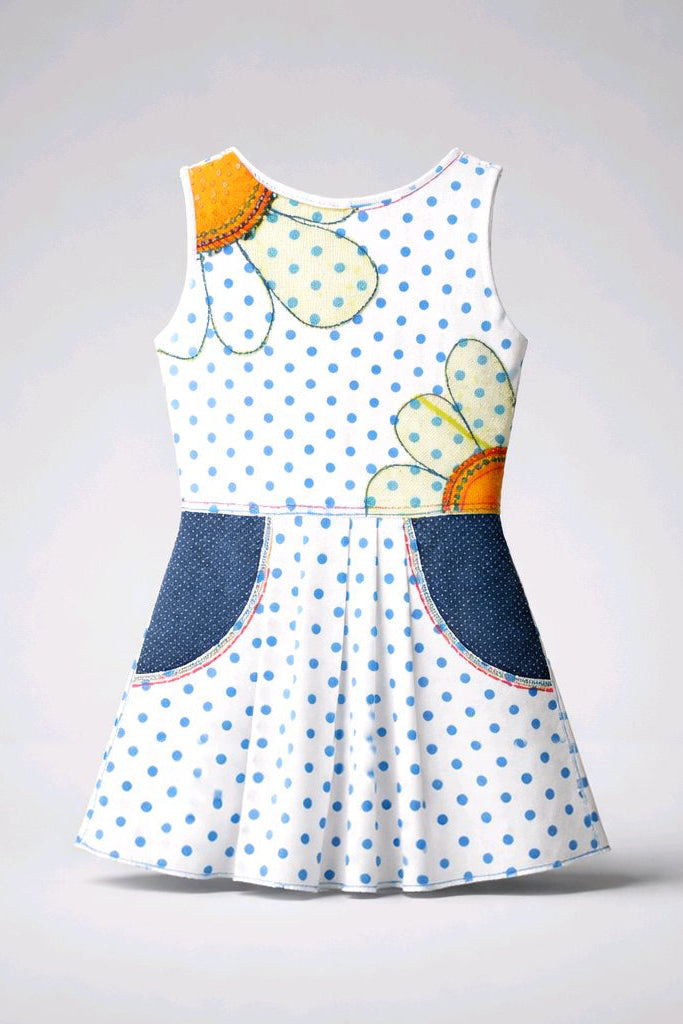 A sleeveless white dress with blue polka dots, featuring a large flower motif on the bodice and two dark blue patch pockets on the skirt.