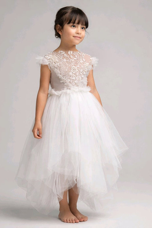 A young girl wearing a white lace and tulle flower girl dress.