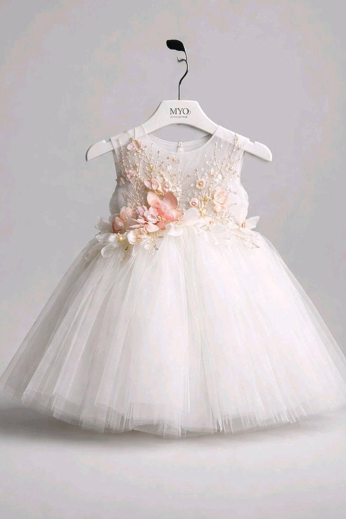 A sleeveless white tulle flower girl dress with 3D floral appliques in pink and cream on the bodice.