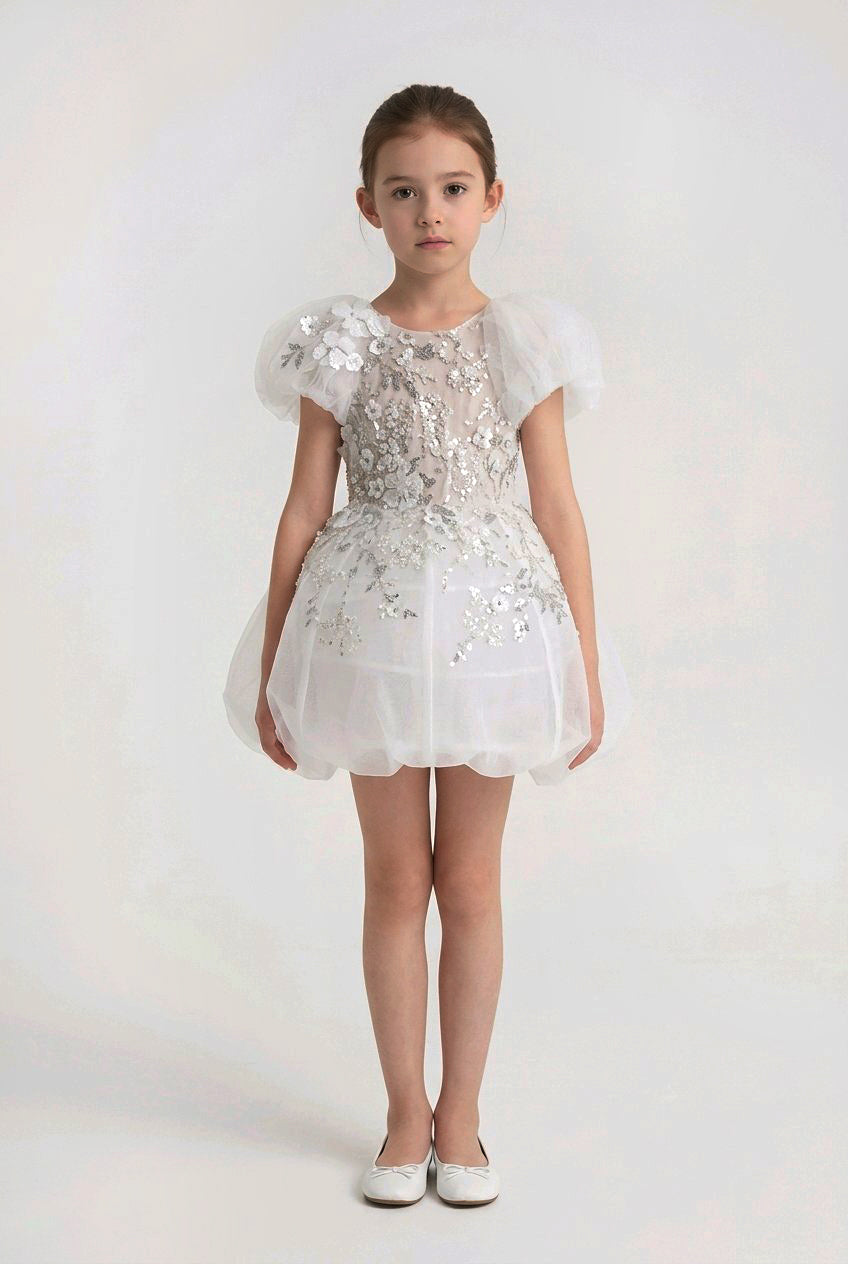 Young girl wearing a white floral dress.